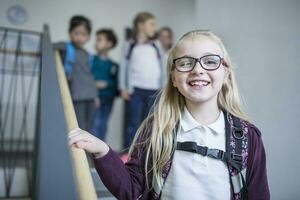 porträtt av Lycklig skol med klasskamrater på trappa lämnar skola foto