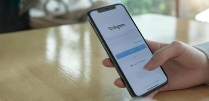 kvinna som håller apple iphone x med instagramapplikation på skärmen foto