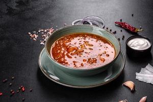 läcker färsk varm borsch med tomat och kött i en keramisk tallrik foto