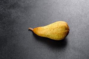 färska läckra saftiga mogna gula päron på en mörk bakgrund foto