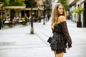 ung brunettkvinna för långt hår som går på gatan foto
