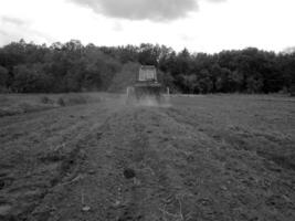 plogade fält förbi traktor i svart jord på öppen landsbygden natur foto