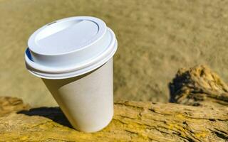 kaffe till gå råna på de strand sand hav vågor. foto