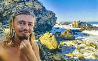 selfie med stenar klippor se vågor strand puerto escondido Mexiko. foto