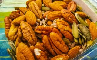 olika nötter i väska pekannötter jordnötter pumpa solros frön mandlar. foto