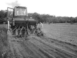 plogade fält förbi traktor i svart jord på öppen landsbygden natur foto