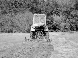 plogade fält förbi traktor i svart jord på öppen landsbygden natur foto