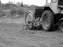 plogade fält förbi traktor i svart jord på öppen landsbygden natur foto