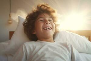 en pojke lyckligt vaknar upp i vit sovrum foto