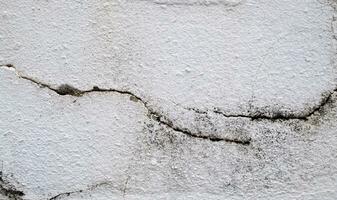 närbild av knäckt betong vägg textur, cement bakgrund inte målad i årgång stil för grafisk design eller retro tapeter, textur spricka i betong vägg foto