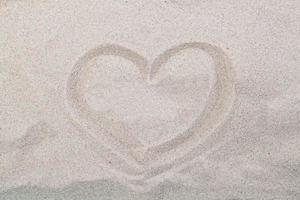havskust. inskription hjärta på strandsand foto