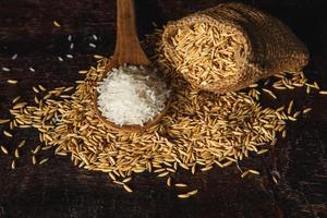 rå ångad ris och ris på träbakgrund foto