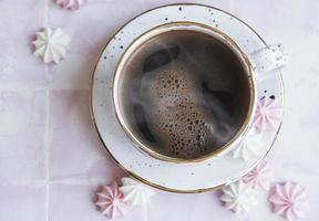 kopp med kaffe och små maränger foto