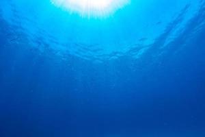 under vattnet av tropiska solstrålar som passerar genom vattnet. foto