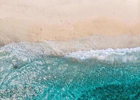 Flygfoto över klara havsvågor och vita sandstränder på sommaren. foto