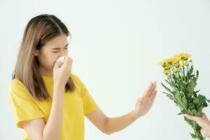 pollen allergier, asiatisk ung kvinna nysning i en näsduk eller blåser i en torka, allergisk till vild vår blommor eller blommar under vår. allergisk reaktion, respiratorisk systemet problem foto