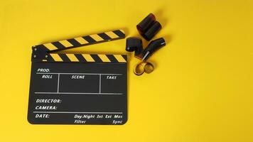 kläpp styrelse eller film skiffer med svart gul Färg och filma rulla på gul bakgrund. den är Begagnade i video produktion och filma industri. foto