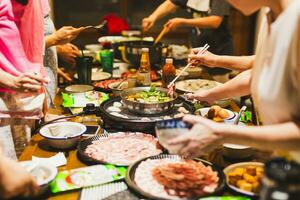 grupp av vänner matlagning de kinesisk shabu köttgryta på Hem. foto