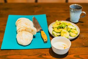 friska frukost med färsk bröd, avokado, koka upp ägg och kopp av kaffe. foto