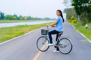 flicka med cykel, kvinna som cyklar på vägen i en park foto