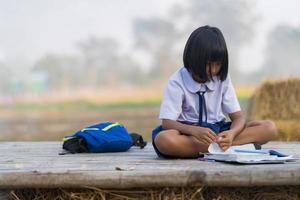asiatisk student i uniform som studerar på landsbygden i Thailand foto
