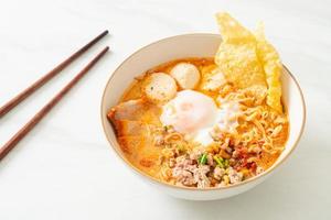 snabbnudlar med fläsk och köttbullar i kryddig soppa eller tom yum-nudlar i asiatisk stil foto