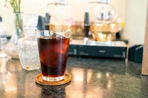 kallt bryggkaffe eller americano svart kaffe i glas med isbit i kafé och restaurang