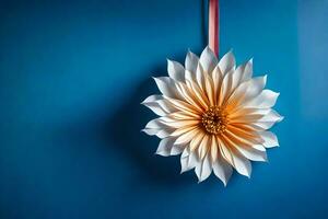 en vit och orange papper blomma hängande på en blå vägg. ai-genererad foto