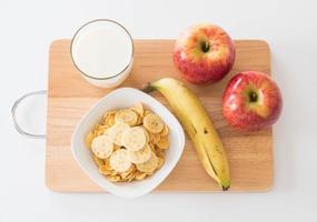 mjölk, äpple, banan och cornflakes till frukost foto