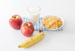 mjölk, äpple, banan och cornflakes till frukost foto