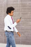 bekymrad svart affärsman som använder sin smartphone utomhus foto