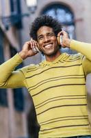 svart man lyssnar på musik med trådlösa hörlurar foto