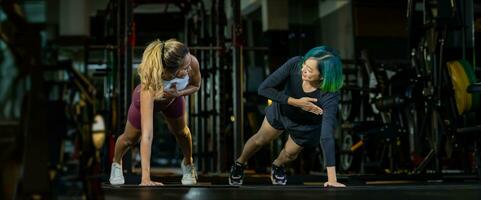 två asiatisk kvinnor Gym partner håller på med bordläggning med axel kran övning på de golv som stärka de magmuskler abdominal och kärna kropp muskel foto