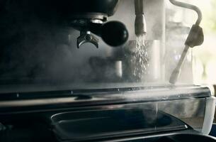närbild av en professionell rostfri stål kaffe maskin frisättande ånga och redo till brygga kaffe drycker foto