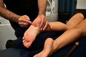 professionell terapeut ger en traditionell zonterapi thai fot massage med pinne i de spa. thai fot massage på de spa salong foto