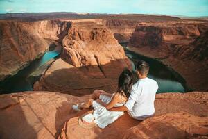 Lycklig par på de kant av de klippa på hästsko band kanjon i paje, arizona. äventyr och turism begrepp. skön natur i USA foto