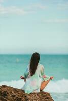 ung kvinna med praktiserande yoga på de strand foto