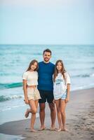 porträtt av far med hans förtjusande döttrar på de strand under deras sommar semester foto