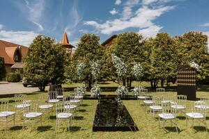 bröllop ceremoni i trädgård. lyxig bröllop ceremoni. romantisk bröllop ceremoni. bröllop båge dekorerad med grönska utomhus - stock Foto