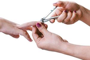 kvinnahanden använder en nagelklippare för att klippa ett barns naglar.