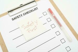 säkerhet först text notera. tom checklista papper under säkerhet granska och risk verifiering. säkerhet checklista form. foto