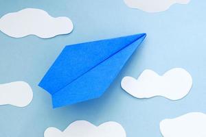 blått papper flygplan och moln, på en blå bakgrund foto