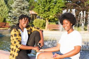 två glada afroamerikanska kvinnor går ner på gatan foto