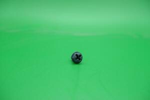 en leksak skruva på en grön bakgrund foto