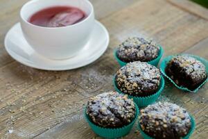 en tabell med en kopp av te och några choklad muffins foto