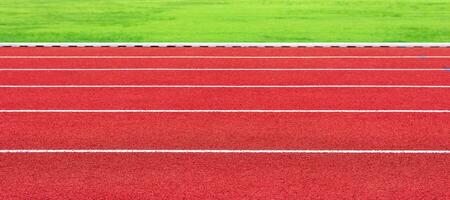 horisontell bild av röd löpning Spår i ett utomhus- sporter stadion. för sporter friidrott eller övning foto