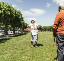 senior tittar på äldre lady spelar med en hoola ring foto