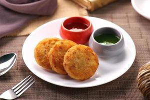 indisk mat aloo ki tikki potatisbiffar serveras med chutney foto