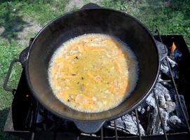 gjutjärnskål pilaf, bred svart tallrik är fylld foto