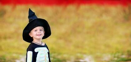 porträtt av en liten pojke bär en skelett kostym och en svart hatt. halloween Semester. foto